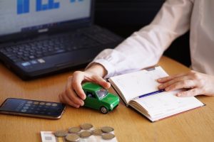 A closeup shot of a person thinking of buying a new car or selling a vehicle