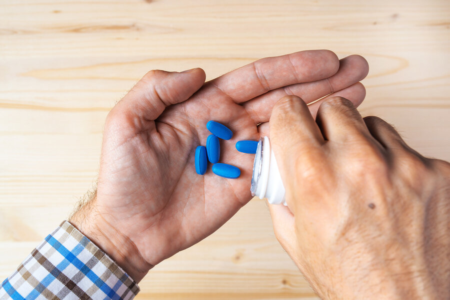 Top view pov of adult man taking blue pills, selective focus