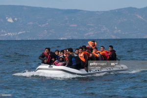 Lesbos, Greece - October 25, 2015: An inflatable boat filled with refugees and other migrants approaches the north coast of the Greek island of Lesbos. Turkey is visible in the background. More than 500,000 migrants have crossed by boat from Turkey to the Greek islands so far in 2015.