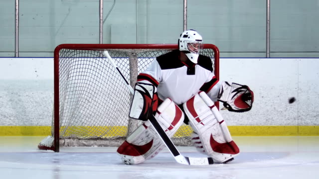 A ice hockey goalie makes a glove save followed by a second shot of him making a blocker save. Both shots are slow motion. Shot on a RED ONE camera at 100 fps.