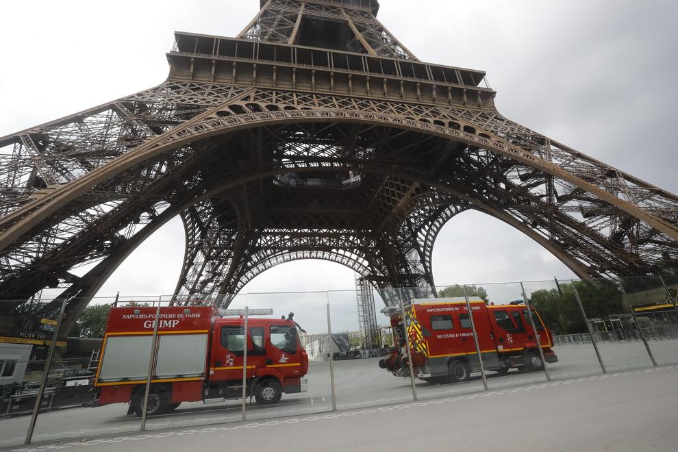 Rescue workers vehicles park just down the Eiffel Tower Monday, May 20, 2019 in Paris. The Eiffel Tower has been closed to visitors after a person has tried to scale it. (ANSA/AP Photo/Michel Euler) [CopyrightNotice: Copyright 2019 The Associated Press. All rights reserved.]