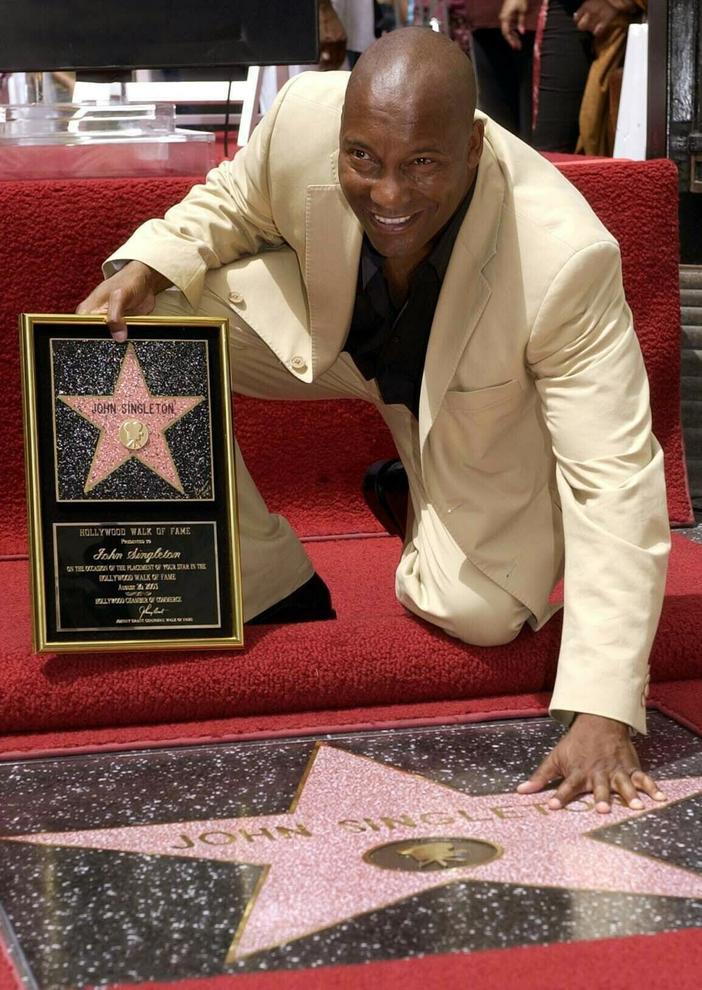FILE - In this Aug. 26, 2003 file photo, director John Singleton touches his new star on the Hollywood Walk of Fame in Los Angeles. Oscar-nominated filmmaker John Singleton has died at 51, according to statement from his family, Monday, April 29, 2019. He died Monday after suffering a stroke almost two weeks ago.  (ANSA/AP Photo/Nick Ut, File) [CopyrightNotice: AP2003]