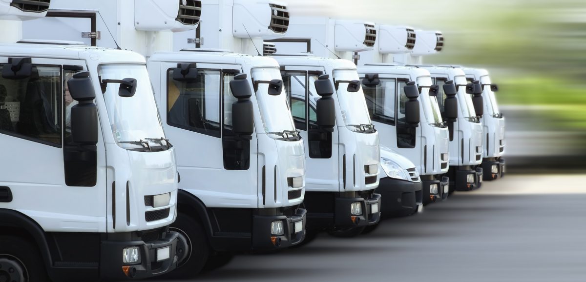 A fleet of delivery truck vehicles used to transport refrigerated goods, high dynamic, motion blurred.