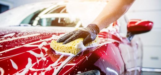 Worker,Washing,Red,Car,With,Sponge,On,A,Car,Wash