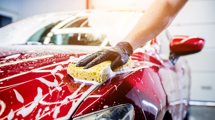 Worker,Washing,Red,Car,With,Sponge,On,A,Car,Wash