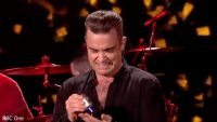 robbie_williams_caught_applying_hand_sanitiser_after_singing_auld_lang_syne__daily_mail_online_640_ori_crop_master__0x0_640x360